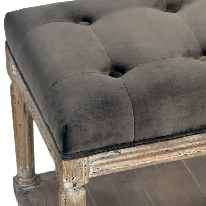 Padded bench with tufted detailing and storage shelf, charcoal gray.